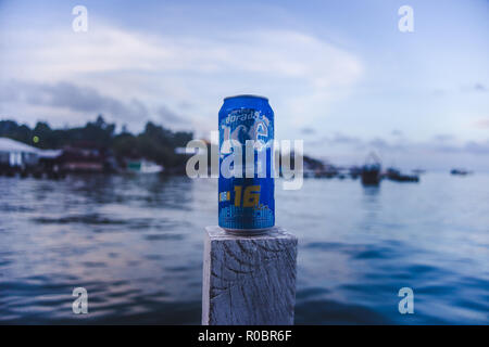 Blue drinks can of Guatemalan beer Dorada Ice being drunk on a jetty in Livingston, on the east coast of Guatemala Stock Photo