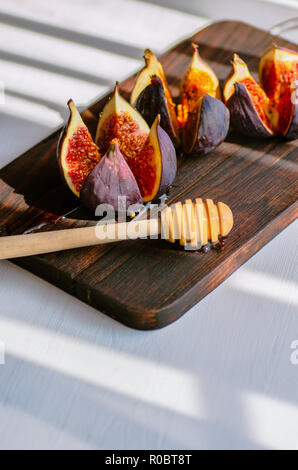 Ripe figs on a dark wooden board. Healthy food concept. Light background. Treatment of anemia. Potassium for the heart. Stock Photo