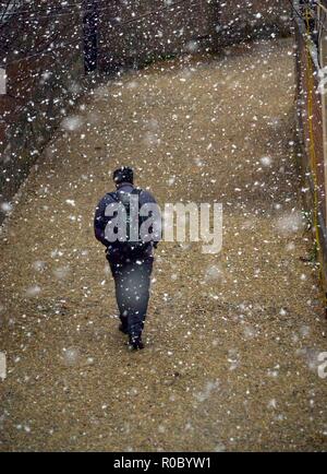 A Kashmiri man walks during the seasons first snowfall in Srinagar, Indian administered Kashmir. Right at the advent of winter, Kashmir valley has received its first snowfall as cold wave like conditions gripped the Valley due to continuous downpour. All weather stations across the Valley Friday witnessed a drop of around 10 degrees Celsius from the normal day temperatures for this time of the year. Stock Photo