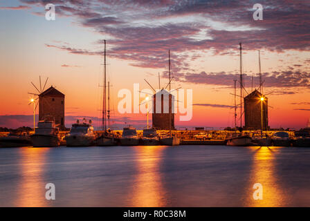 Windmills on the harbour pier. Rhodes town, Greece. Stock Photo
