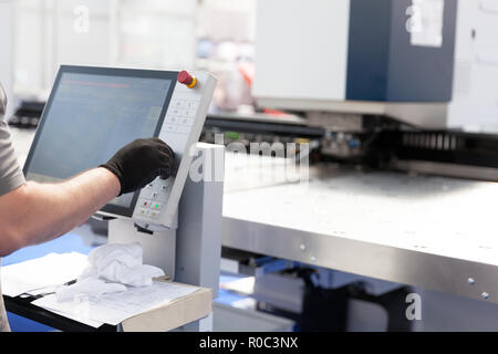 An operator working at programmable machine. Computer numerical control (CNC) machine Stock Photo