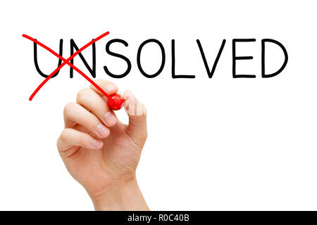 Hand changing the word Unsolved into Solved with red marker isolated on white in solution concept. Stock Photo