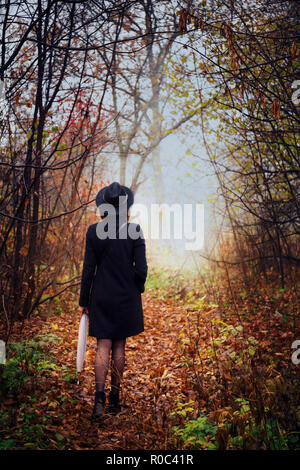 A young woman sneaks through the thickets Stock Photo