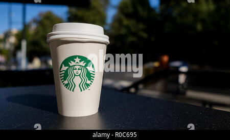 Starbucks beverage and coffee cup on the table with people in the ...