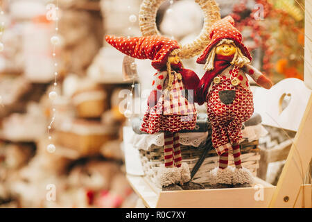 Rustic christmas toys, elves and gnomes gifts on window in european city street. Simple Festive decorations and illumination in winter holidays in tow Stock Photo