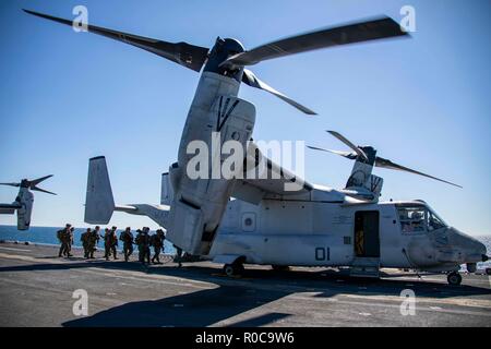 181029-N-KW492-0135 ATLANTIC OCEAN (Oct. 29, 2018) Marines assigned to the 22nd Marine Expeditionary Unit (MEU) embark an MV-22 Osprey on the flight deck of the Wasp-class amphibious assault ship USS Kearsarge (LHD3) during the Carrier Strike Group (CSG) 4 composite training unit exercise (COMPTUEX). COMPTUEX is the final pre-deployment exercise that certifies the combined Kearsarge Amphibious Ready Group's and 22nd MEU's abilities to conduct military operations at sea and project power ashore through joint planning and execution of challenging and realistic training scenarios. CSG 4 mentors,  Stock Photo