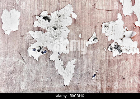Beige old ruin wall with peeled plaster, cracks and bullet holes on it Stock Photo