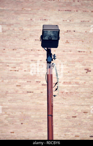 Retro rusty street lamp post on brick wall background Stock Photo