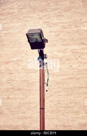 Retro rusty street lamp post on brick wall background Stock Photo
