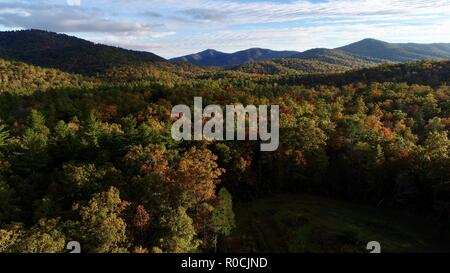 Aerial (drone) captured sunset with colorful hardwood forest and trees, mountains during autumn in Pisgah National Forest, North Carolina, USA. Stock Photo