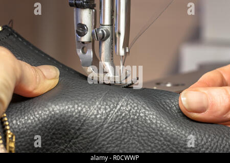 Hands working on a Leather sewing machine in action Stock Photo