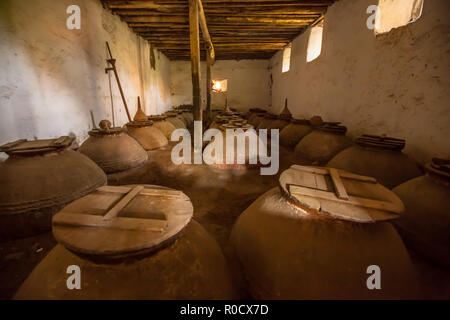 Dark brown old historic Olive oil storage cellar with ceramic pots in Greece Stock Photo
