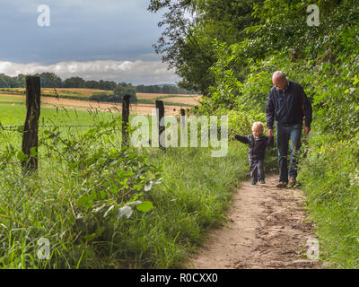 grandfather is walking with child on a walking track with family in nature Stock Photo