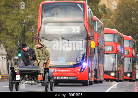 Westminster Bridge, London, UK, 4th Nov 2018. A veteran car crosses the bridge ahead of a long queue of red double decker buses. The World's longest running motoring event, Bonhams London to Brighton Veteran Car Run, sets of from Hyde Park and along Constitution Hill by Buckingham Palace, the Mall and Admiralty Arch, then along a 60 mile route all the way to Brighton. It is this year in its 122nd anniversary run. More than 400 of the veteran cars are from the pre-1905 era. Credit: Imageplotter News and Sports/Alamy Live News Stock Photo