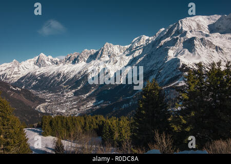Big snowy mountains and village under them, on a sunny winter day, Les Houches, France Stock Photo