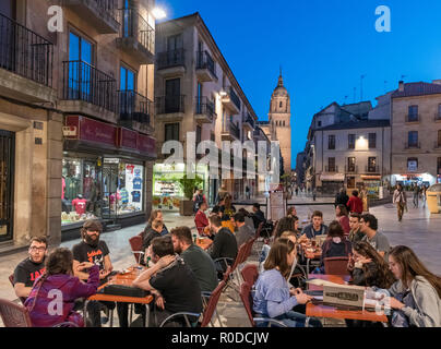 Students at a cafe at night on Calle Rúa Mayor looking towards the tower of the Old Cathedral, Salamanca, Castilla y Leon, Spain Stock Photo