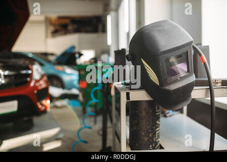Welding helmet in car service , nobody. Professional auto-service tools and equipment, auto body works Stock Photo