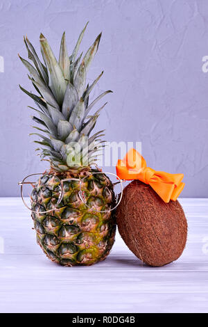 Stylish pineapple and coconut on grey background. Stock Photo
