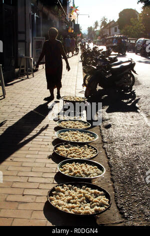 Sticky rice drying on the sidewalk in the sun at end of day, Luang Prabang, Laos Stock Photo