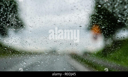 Abstract background - View of the road through the rain drops-covered window. Stock Photo