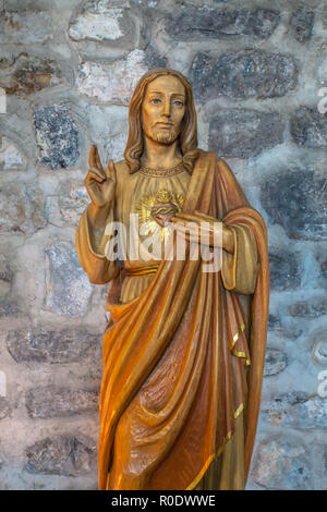 Wood Carving of The Lord against wall Stock Photo