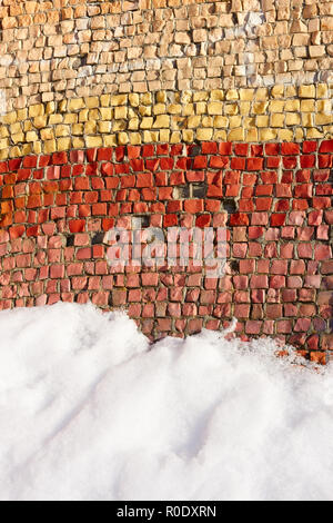 Fragment of an old colortul mosaics partially covered with snow in fine winter day Stock Photo