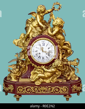 Antique mantel clock of golden cupid and angel statuettes, on isolated green background with clipping path. Stock Photo