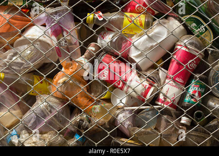 SANGHLABURI, THAILAND, JANUARY 24, 2016 : A fenced public bin is full of soda cans, glass bottel and other drinks in Sangkhlaburi, Thailand Stock Photo