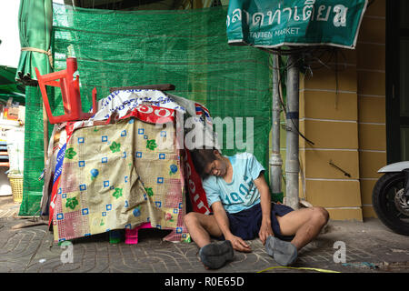 BANGKOK, THAILAND, FEBRUARY 18 , 2014 : Drunk man lying in a small street of the Phra Nakhon district during the Chinese new year celebration in Bangk Stock Photo