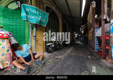 BANGKOK, THAILAND, FEBRUARY 18 , 2014: Drunk man lying in a small street of the Phra Nakhon district during the Chinese new year celebration in Bangko Stock Photo