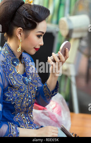 BANGKOK, THAILAND, February 17, 2015: A Thai lady traditional dancer is checking her makeup make up on a mirror before the show celebrating the new Kr Stock Photo