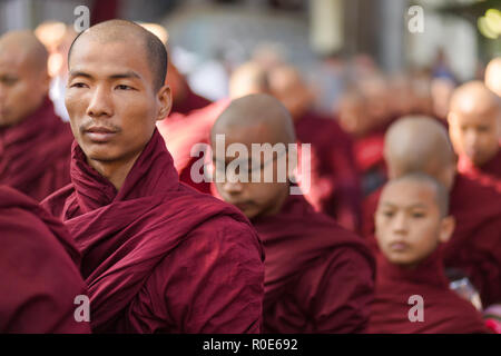 AMARAPURA, MYANMAR, JANUARY 20, 2015 : Buddhist monks are queuing to collect the unique daily meal at noon in the Mahagandayon monastery near Mandalay Stock Photo