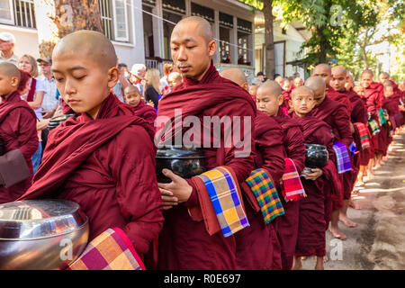 AMARAPURA, MYANMAR, JANUARY 20, 2015 : Young monks are queueing holding their bowls to collect the unique daily meal at noon in the Mahagandayon monas Stock Photo