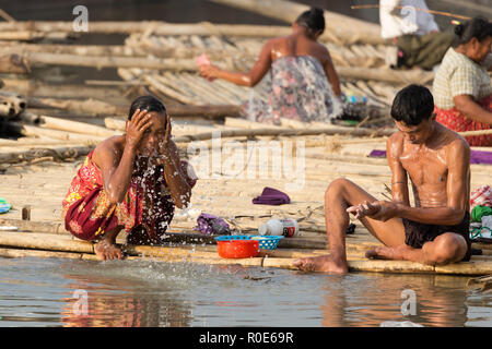 MANDALAY,MYANMAR,JANUARY 19, 2015 : Women taking shower and washing dishes in a slum area at the Irrawaddy river in Mandalay, Myanmar (Burma). Stock Photo