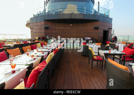BANGKOK, THAILAND, JANUARY 14, 2015: Restaurant table with view on the cityscape at the Red Sky Rooftop of the Centara hotel in Bangkok, Thailand. Stock Photo
