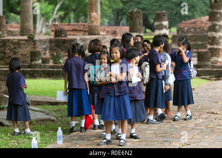 SUKHOTHAI, THAILAND, JULY 12, 2013: An elementary school is out for studying the historical Buddhist park in Sukhothai, Thailand Stock Photo