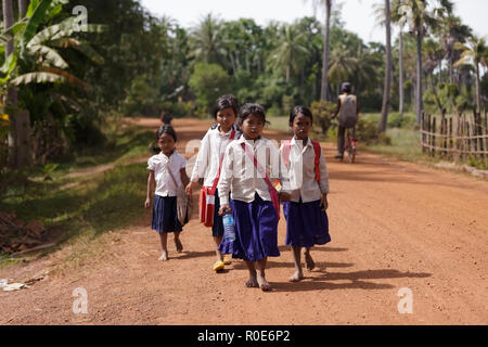SIEM REAP, CAMBODIA, DECEMBER 04 : Cambodian little girls students in traditional clothes walking on a countryside dirt road near Siem Reap, Cambodia  Stock Photo