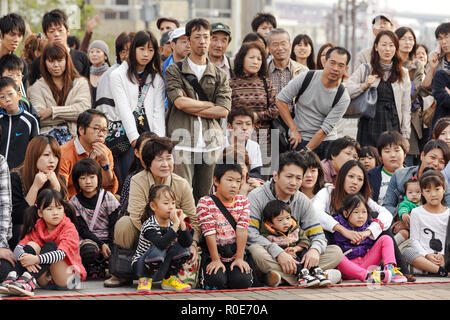 OSAKA, JAPAN, NOVEMBER 13, 2011: Japanese public crowd is watching a magician show performed at the aquarium square in Osaka, Japan Stock Photo