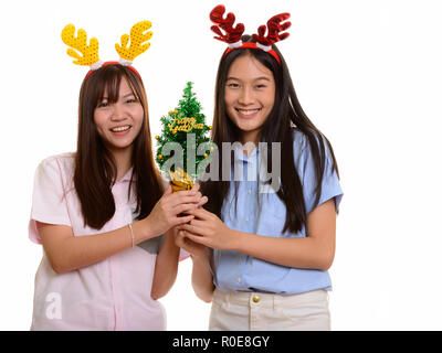 Two young happy Asian teenage girls smiling holding Happy New Ye Stock Photo