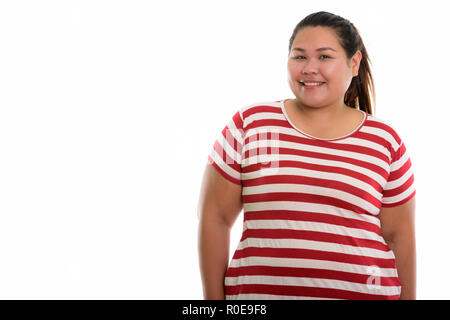 Studio shot of young happy fat Asian woman smiling  Stock Photo