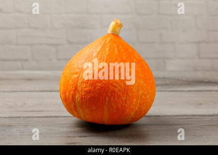 Red kuri squash (Hokaido pumpkin) on gray wood table. Stock Photo