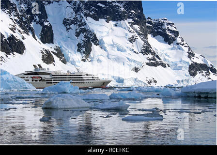 An Antarctic Expedition cruise ship at anchor amid the glistening icy waters of Paradise Bay in the Antarctic Peninsula on a sunny Summer's day Stock Photo