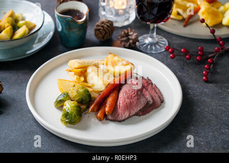 Traditional roast dinner with beef, carrots, brussel sprouts and gravy Stock Photo