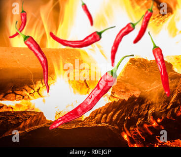 a few pieces of red chili peppers on background with fire Stock Photo