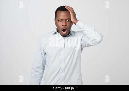 Shocked black male says wow, looks with wide opened eyes and rounded mouth Stock Photo