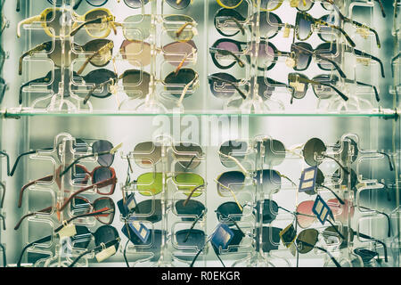 Sunglasses on glass shelves in a shop window, a summer accessory Stock Photo