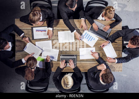 Business people analyzing financial documents showing income, charts and graphs, teamwork concept Stock Photo