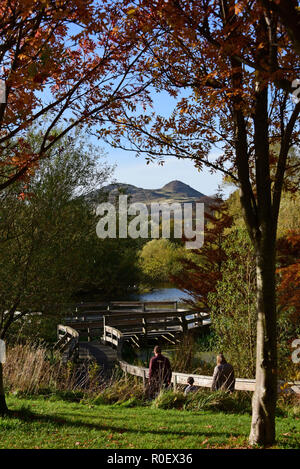 Scotland, UK. 4th Nov 2018.  A family strolls in the late autumn sun in Figgate Park, with Arthur's Seat - the extinct volcano in the heart of Edinburgh - in the background, © Ken Jack / Alamy Live News Stock Photo