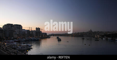 Panoramic view of the dark night and the very early start of the dawn over the Grand Harbor of Valletta Stock Photo