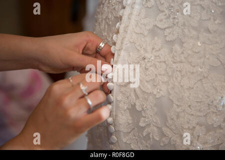 Close up of wedding dress being done up on the brides wedding day Stock Photo